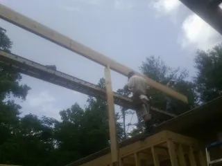 Carpenter setting a ridge beam over a new addition frame — Ice Dam Removal by Roofing Brothers in Dresher