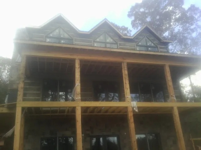 Dormers and porch framing on a large log home under construction — Roof Coating work by our crew in Dresher