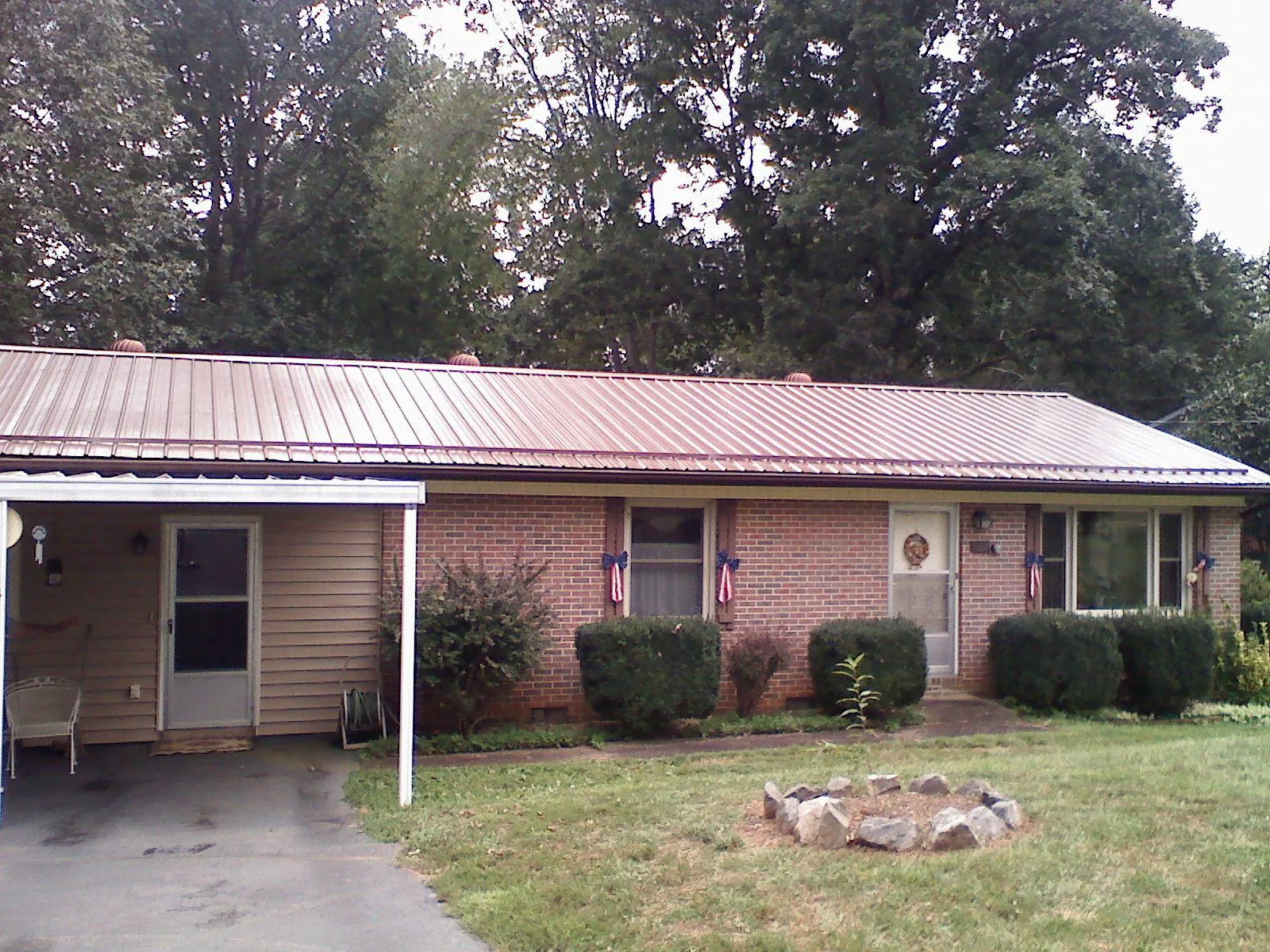 Bronze metal roof and carport on a brick ranch home — Roof Repair work by our crew in Dresher